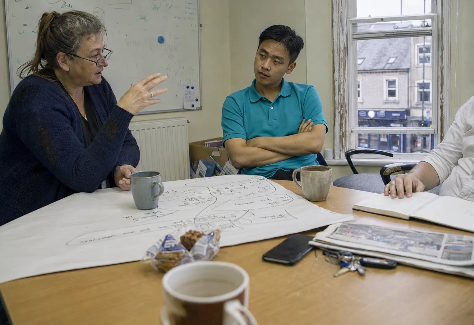 Three colleagues planning a new care business around a table in a small office.